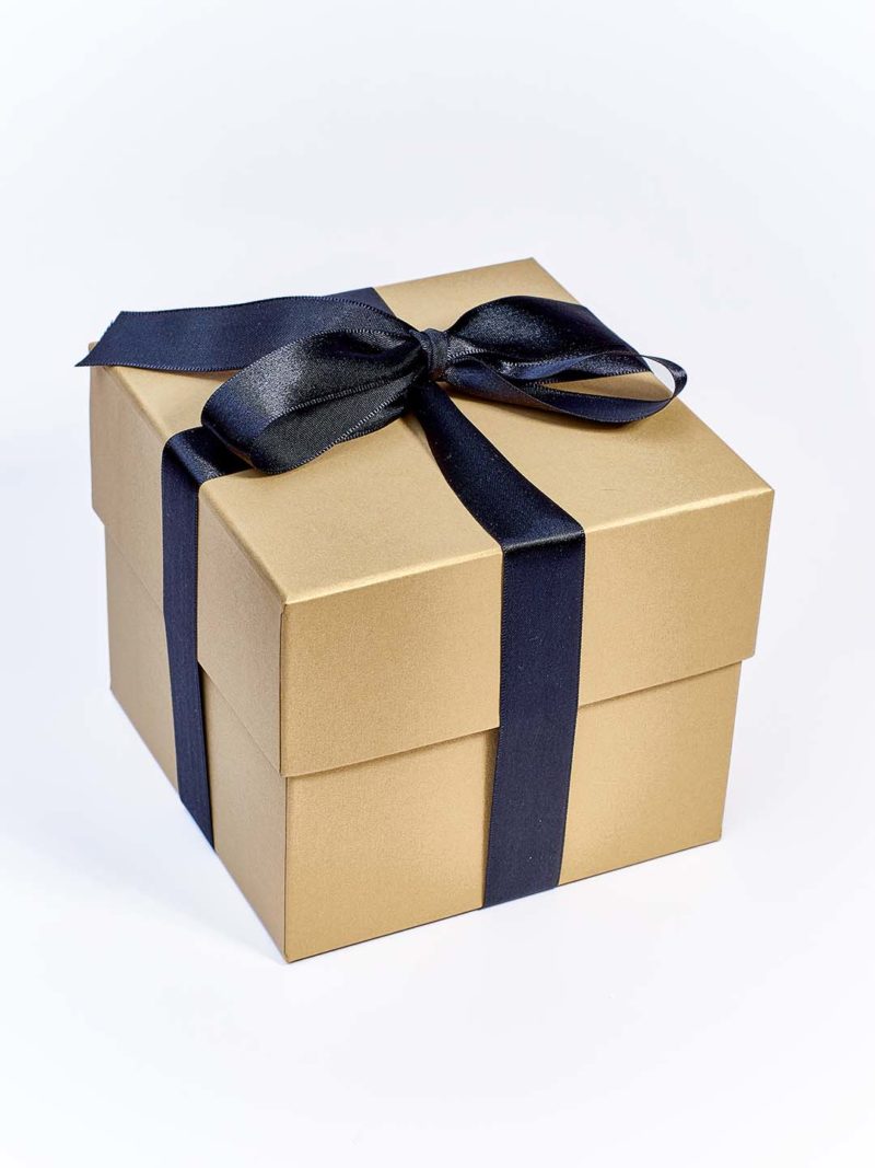 Caixa cartonada com fita preta usada para embalar a vela perfumada